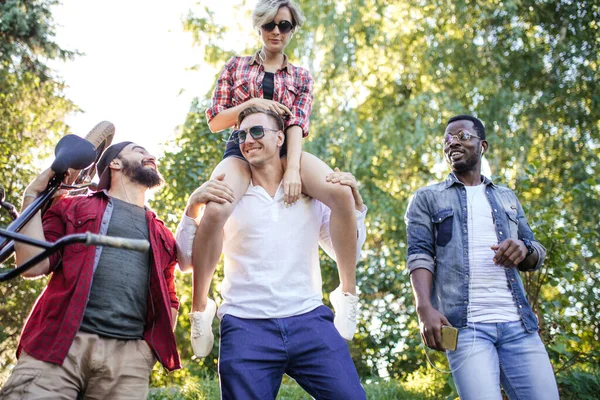 Diverse students relaxing outdoor after classes in college campus.