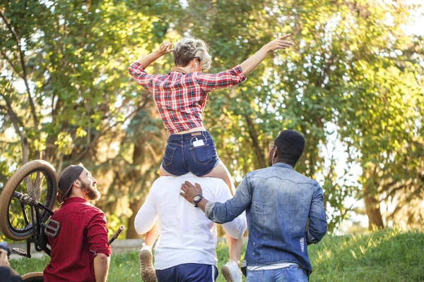 Jovem coupé no parque. Namorado carregando sua namorada em piggyback . — Fotografia de Stock