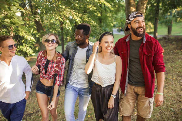 Beste multiraciale vrienden samen rondhangen en wandelen in het park in de zomerdag. — Stockfoto