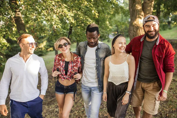 Multi-etnische groep vrienden wandelen en rotzooien rond het stadspark. — Stockfoto