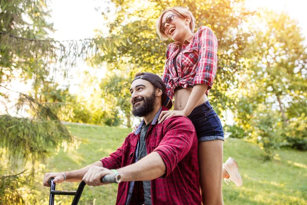 Boldog fiatal pár megy biciklizni egy nyári napon a parkban. — Stock Fotó