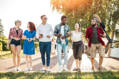 Çok ırklı arkadaş grubu şehir parkında dolanıp duruyor..