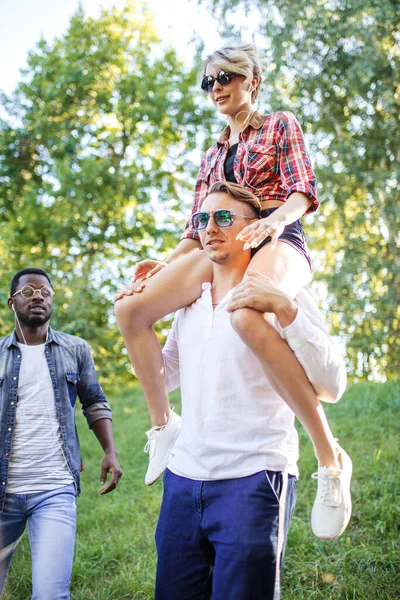 Beste multiraciale vrienden samen rondhangen en wandelen in het park in de zomerdag. — Stockfoto
