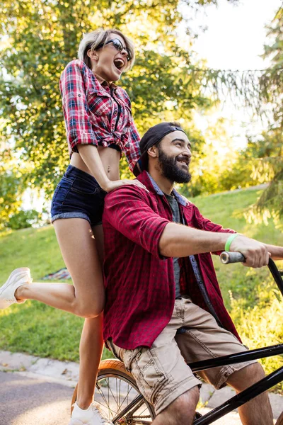 情侣们在业余时间骑一辆自行车，在阳光明媚的夏日玩得很开心. — 图库照片