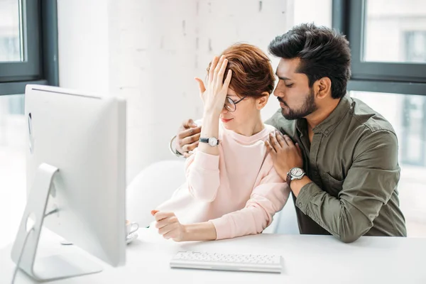 Бизнесмен и женщина коллеги смотрят на компьютер, пытаясь решить проблемы в офисе — стоковое фото