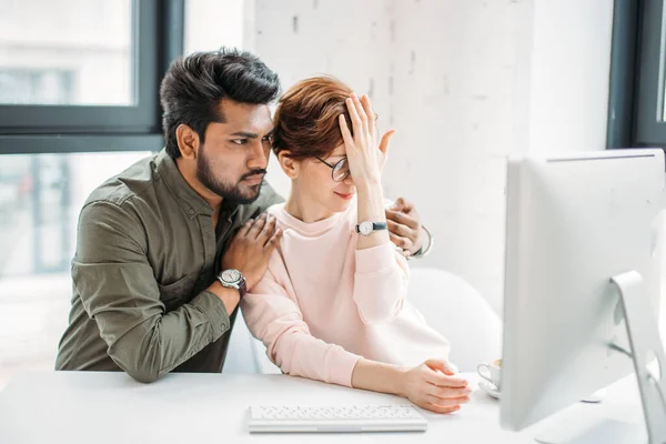 Бизнесмен и женщина коллеги смотрят на компьютер, пытаясь решить проблемы в офисе — стоковое фото