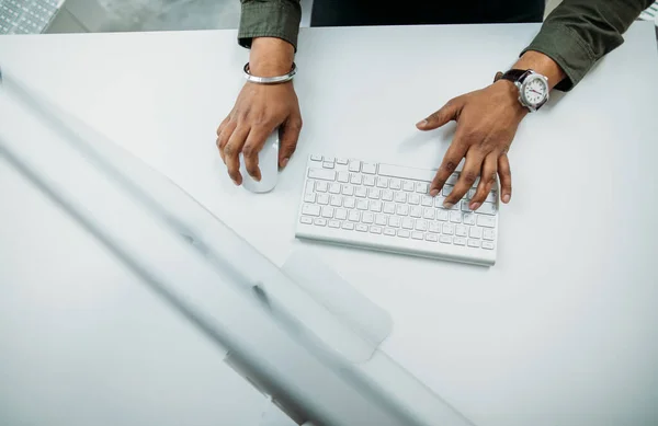 사람이 식탁 위에서 컴퓨터 키보드를 손으로 잡고 있다 — 스톡 사진