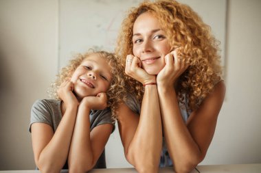 Gülümseyen anne ve sevimli kızı kameraya bakıyor..