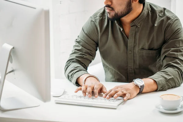 Indian man som arbetar vid datorn från moderna ljusa kontor — Stockfoto