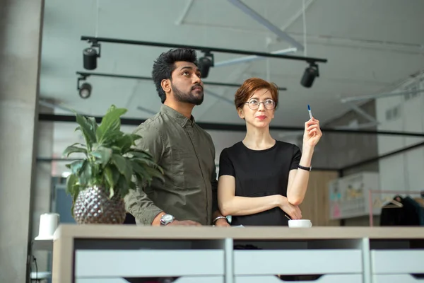 Üzlettársak állnak az irodaházban és üzletekről beszélnek, nő mutatja munkatársának az új irodáját — Stock Fotó