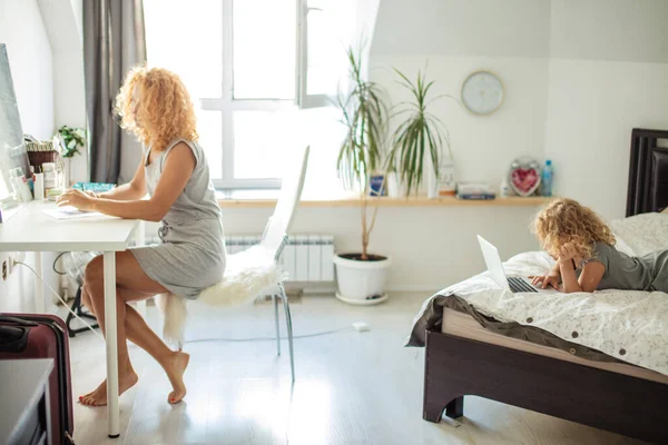 Happy daughter and mother relaxing in living room busy with day-to-day stuff. — Stock Photo, Image
