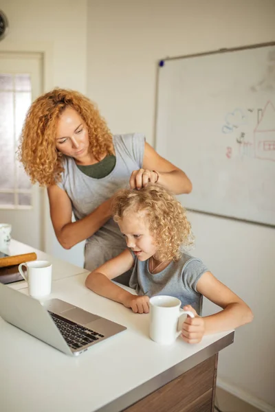Smiling Mother helps her adorable daughter with homework at living room — Stock Photo, Image