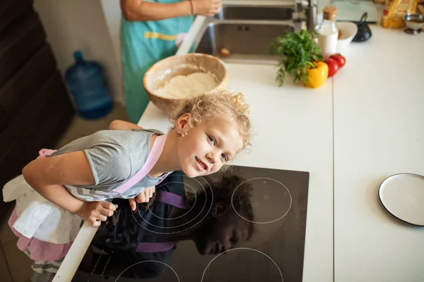 Attrayant jeune femme et sa petite fille mignonne cuisinent à la cuisine. — Photo