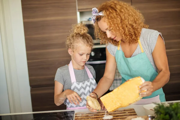 Frau und süße Tochter kochen in Küche und machen Teig für Geburtstagsparty. — Stockfoto