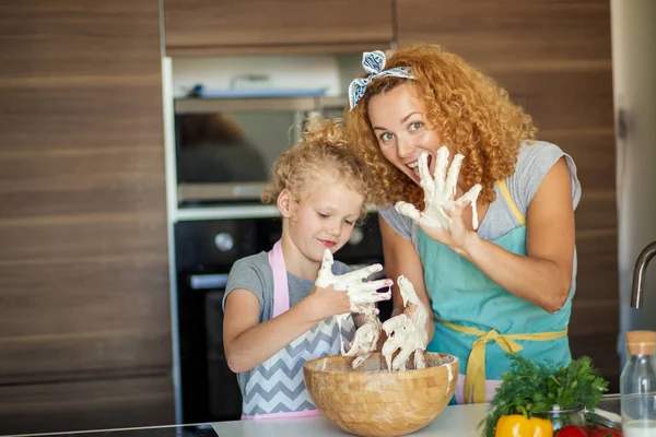 Matka i dziecko córka dobrze się bawią podczas kolacji w kuchni. — Zdjęcie stockowe