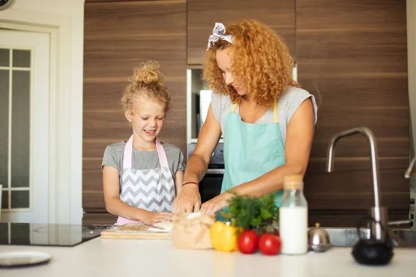 Frau lehrt Kind Teig machen, Ei zu Mehlstapel auf Küchentisch hinzufügen. — Stockfoto