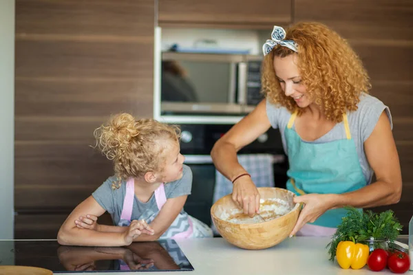 Frau lehrt Kind Teig machen, Ei zu Mehlstapel auf Küchentisch hinzufügen. — Stockfoto