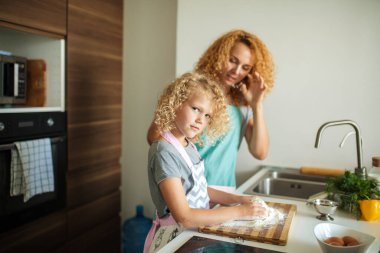 Mutfakta yemek pişiren, doğum günü partisi için para kazanan bir kadın ve güzel bir kız..