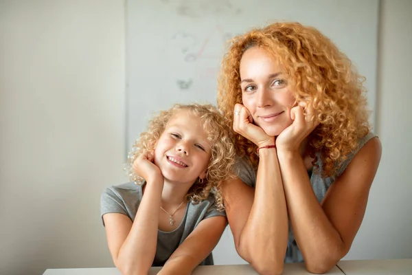 Mère souriante et sa fille adorable regardant la caméra. — Photo