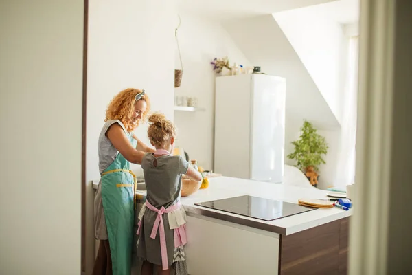 Yemek pişirme ve ev konsepti - Anne ve kızı evde hamur yoğururken dikiz manzarası — Stok fotoğraf