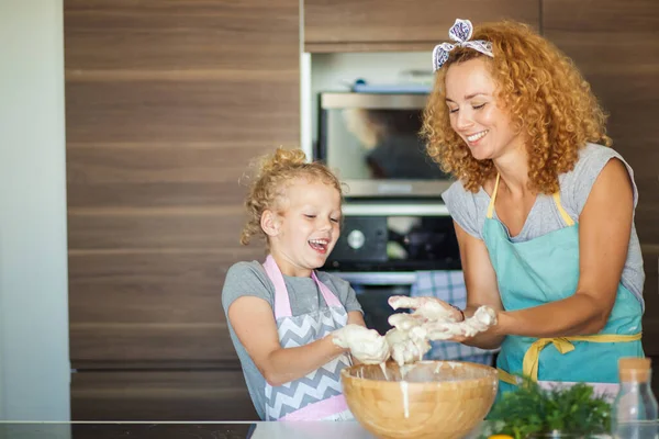 Madre e hija niña divirtiéndose mientras hacen la cena en la cocina. —  Fotos de Stock