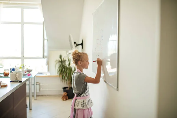 Niña con mamá escribiendo a bordo con rotulador. Aprendizaje y concepto escolar. —  Fotos de Stock