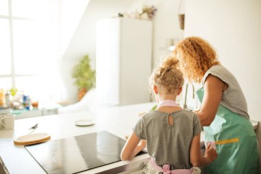 Yemek pişirme ve ev konsepti - Anne ve kızı evde hamur yoğururken dikiz manzarası