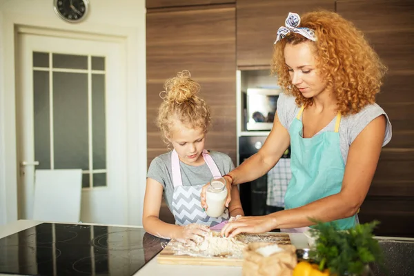 台所で幸せな家族だ。母親と子供の娘が一緒に料理する. — ストック写真