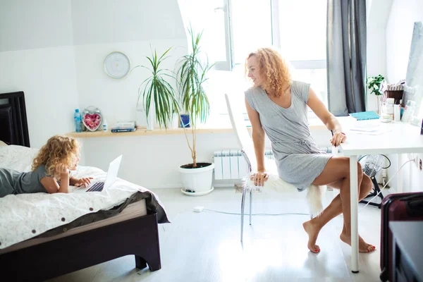 Happy daughter and mother relaxing in living room busy with day-to-day stuff. — Stock Photo, Image