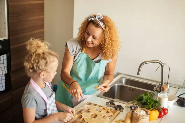Παιδί και γυναίκες κόβουν φόρμα για μπισκότο στη ζύμη. Ευτυχισμένη οικογένεια και παιδική ηλικία. — Φωτογραφία Αρχείου