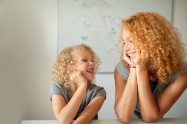 Gülümseyen anne ve sevimli kızı kameraya bakıyor..