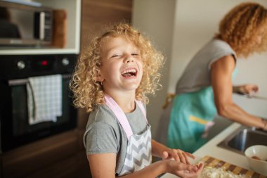 Mutfakta yemek pişiren, doğum günü partisi için para kazanan bir kadın ve güzel bir kız..