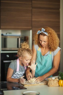 Mutfakta yemek pişiren, doğum günü partisi için para kazanan bir kadın ve güzel bir kız..