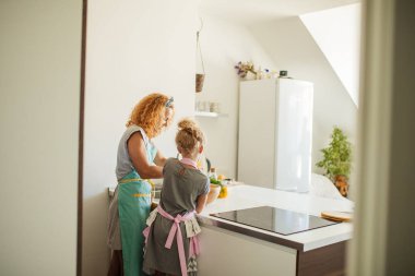 Yemek pişirme ve ev konsepti - Anne ve kızı evde hamur yoğururken dikiz manzarası