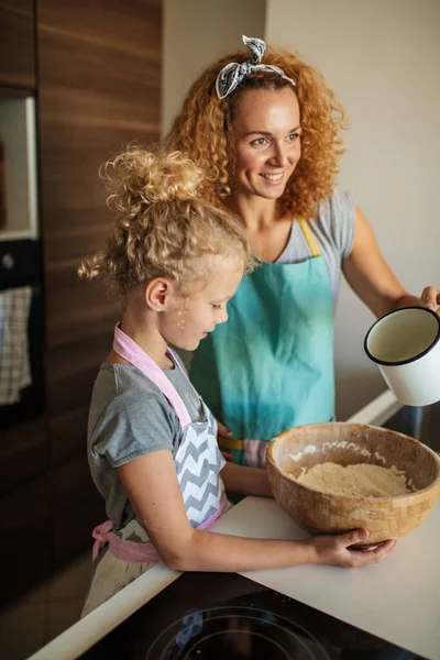 Hijita ayudando a mamá a hornear en la cocina, la familia y la cocina — Foto de Stock