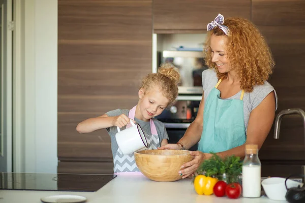 Μικρή κόρη βοηθώντας μητέρα ψήσιμο στην κουζίνα, την οικογένεια και το μαγείρεμα — Φωτογραφία Αρχείου