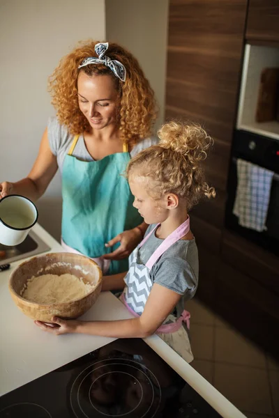 Μικρή κόρη βοηθώντας μητέρα ψήσιμο στην κουζίνα, την οικογένεια και το μαγείρεμα — Φωτογραφία Αρχείου