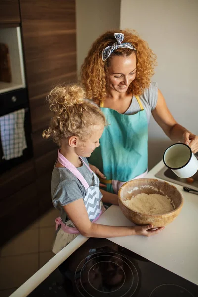 Filhinha ajudando mãe assar na cozinha, família e cozinhar — Fotografia de Stock