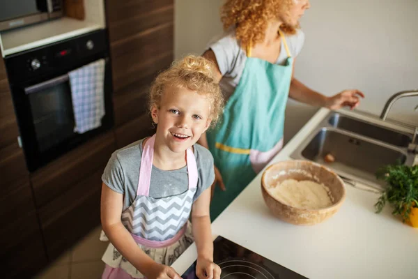 Attrayant jeune femme et sa petite fille mignonne cuisinent à la cuisine. — Photo