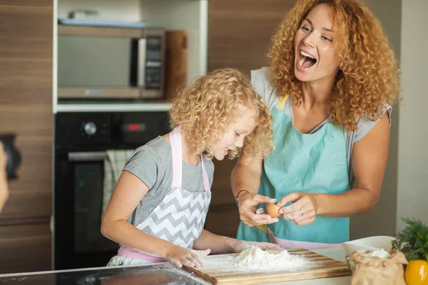 Mujer y linda hija cocinando en la cocina, haciendo masa para la fiesta de cumpleaños. —  Fotos de Stock