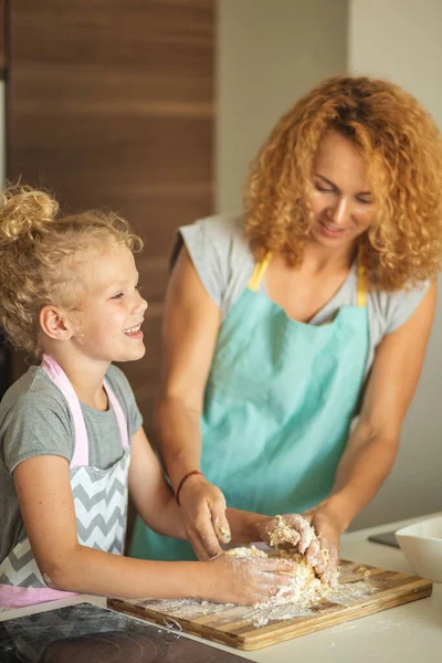 Mujer y linda hija cocinando en la cocina, haciendo masa para la fiesta de cumpleaños. —  Fotos de Stock