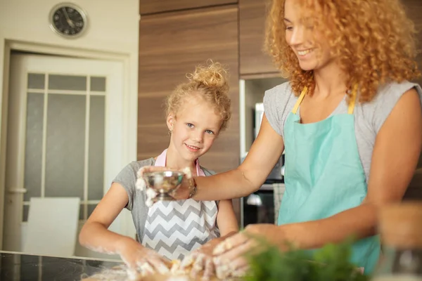 台所で幸せな家族だ。母親と子供の娘が生地を準備クッキーを焼く — ストック写真