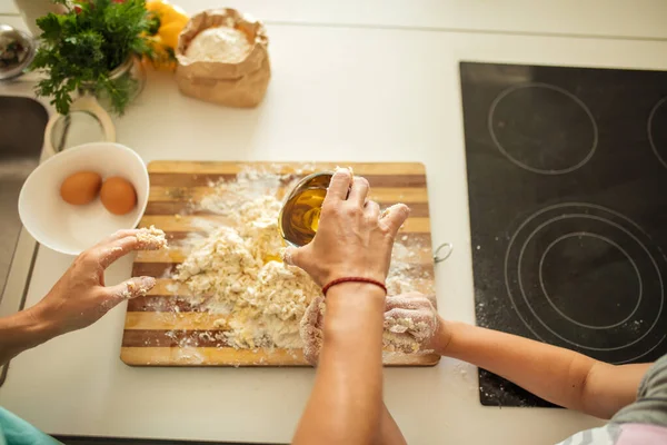 キッチンで料理をしながらクッキーを作る女性と小さな娘のトップビュー. — ストック写真