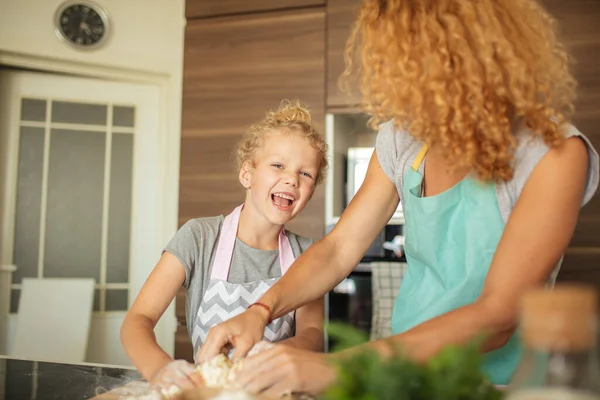 台所で夕食を作りながら楽しい時間を過ごしている母親と子供の娘. — ストック写真