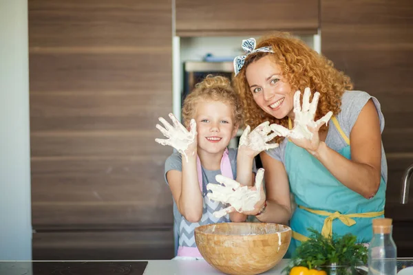 Anne ve kız çocuk mutfakta yemek yaparken eğleniyorlar..