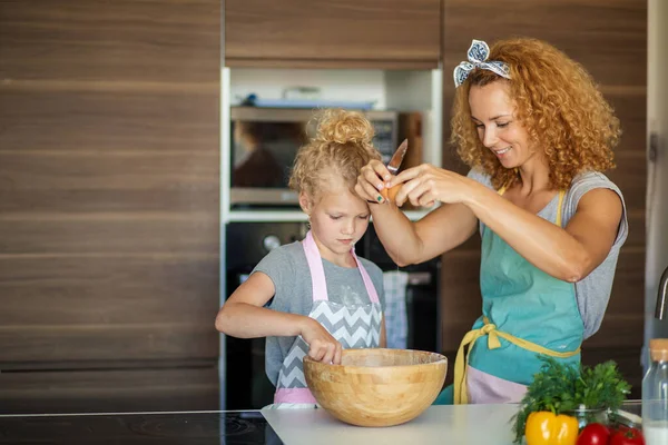 生地を作るために子供を教える女性,キッチンテーブルの上に小麦粉の山に卵を追加. — ストック写真