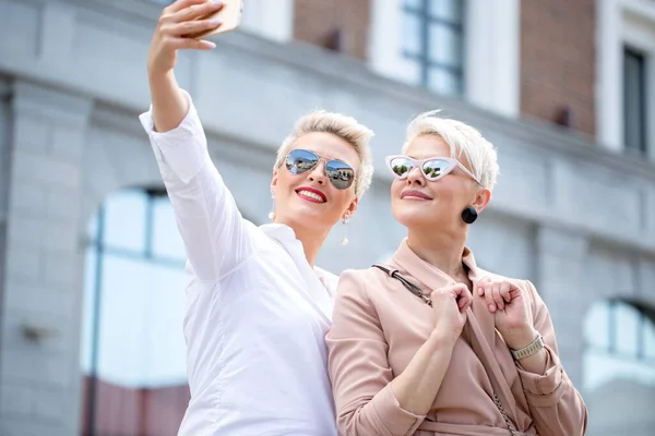 Snygga vuxna affärskvinnor posera för selfie utanför nära kontorsbyggnad — Stockfoto