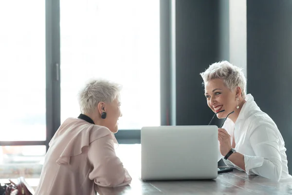 Bizneswoman i klient omawiający możliwe umowy wewnątrz — Zdjęcie stockowe