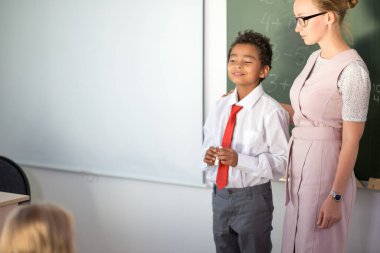 Çocuk toplama ve çıkarma işlemlerini çözüyor. okul çocuğu matematiksel işlemin yazım çözümü