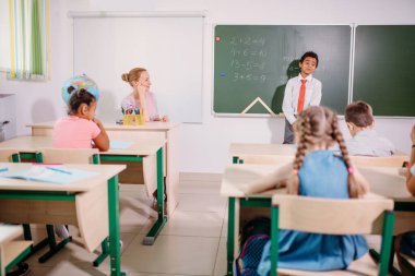 Çocuk toplama ve çıkarma işlemlerini çözüyor. okul çocuğu matematiksel işlemin yazım çözümü